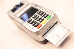 silver American express chip card shown dipped, or being processed, in an emv terminal